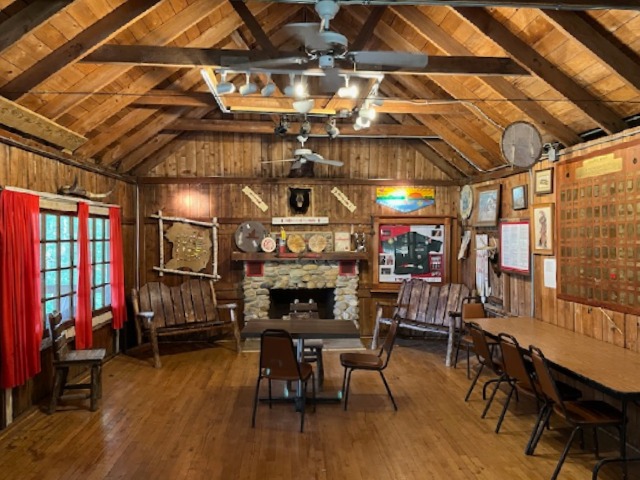 The interior of the business center shows a number of chairs and desks, with wooden paneling and rustic decorations.